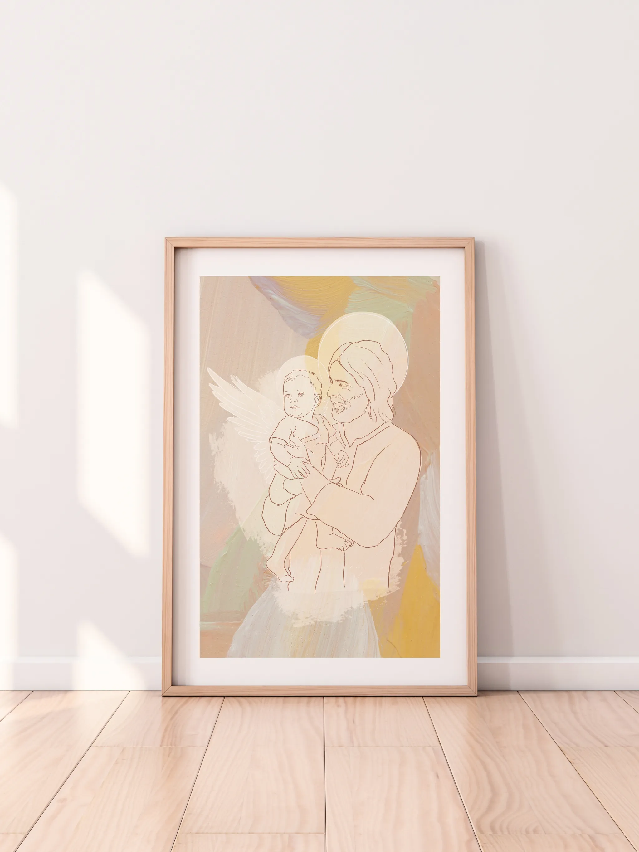 Angel Baby with Christ, framed in light wood with a white mat, leaning against a pale wall on a light wood floor.