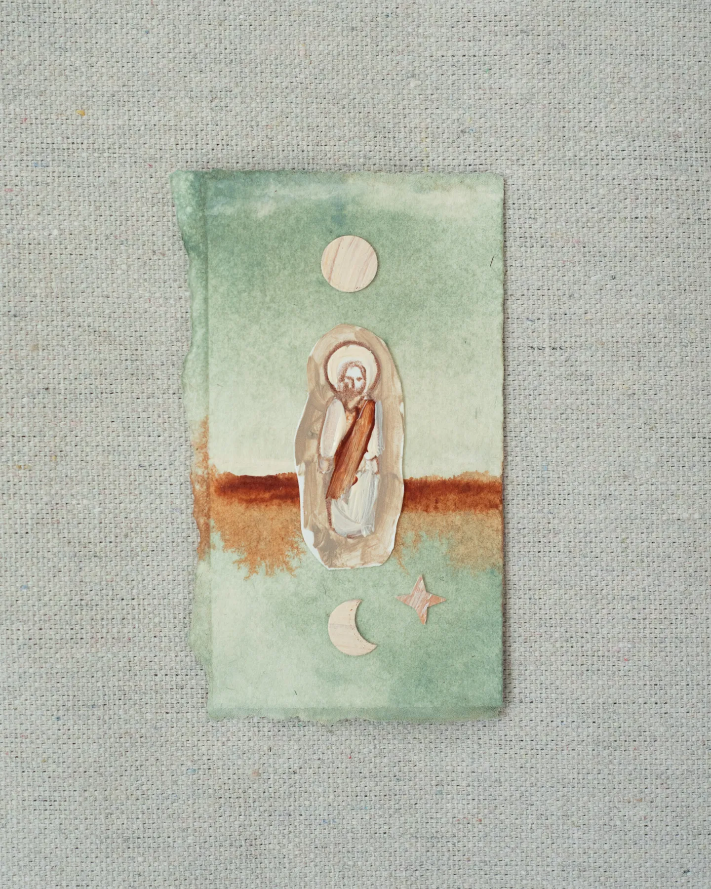 A small painting on torn-edged paper, laid on linen: a figure of Christ in a pale oval on sage green crossed by a band of rust, with a full moon above and a crescent moon and a small star below.