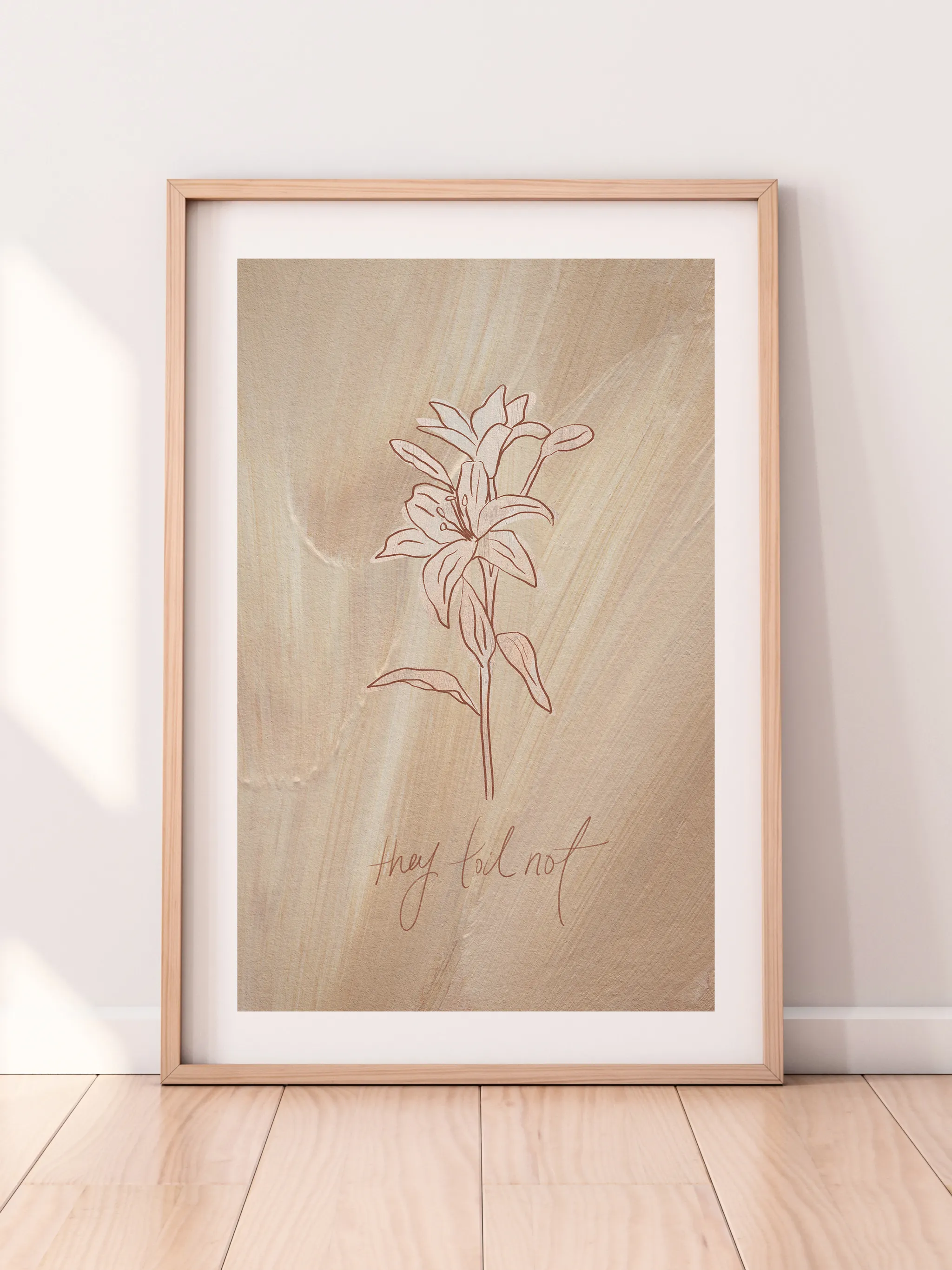 Consider the Lilies on Tan, framed in light wood with a white mat, leaning against a pale wall on a light wood floor.