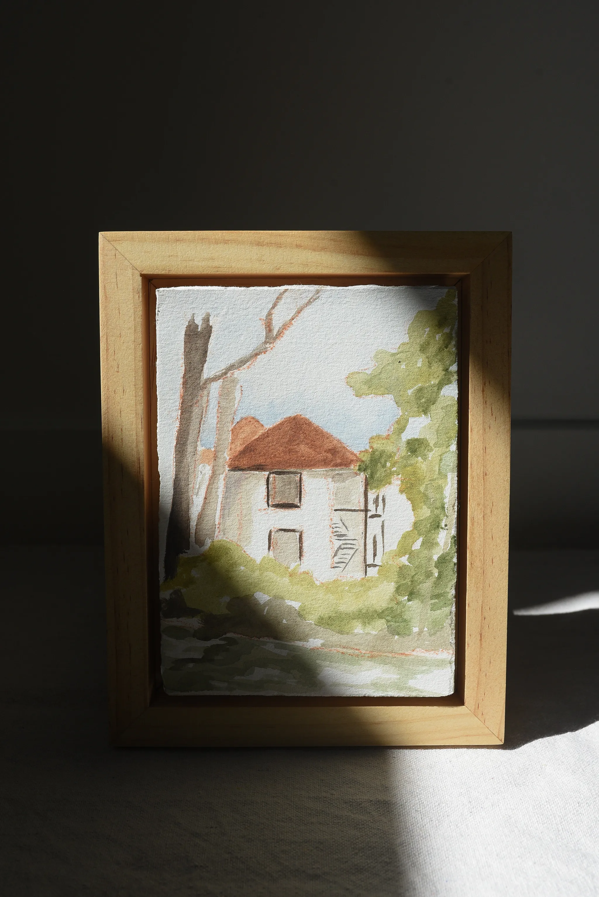 Cottage in the Trees, view 4 of 7: A charming house on the river, surrounded by trees in bright, light tones reminiscent of classic watercolor techniques.