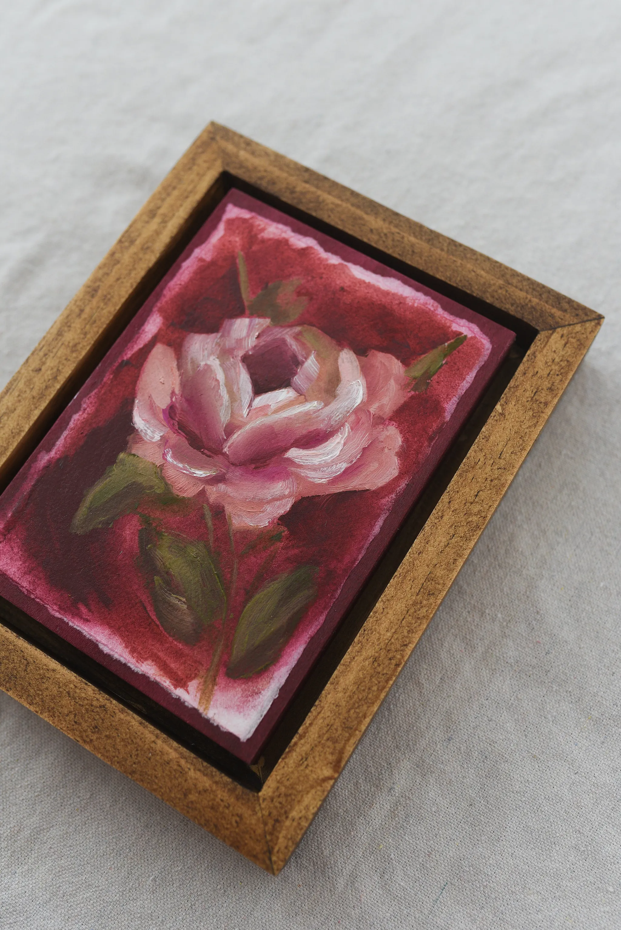 Elegant Bloom, view 8 of 9: A rose blooms against a deep magenta background, rendered in acrylic and oil on paper.