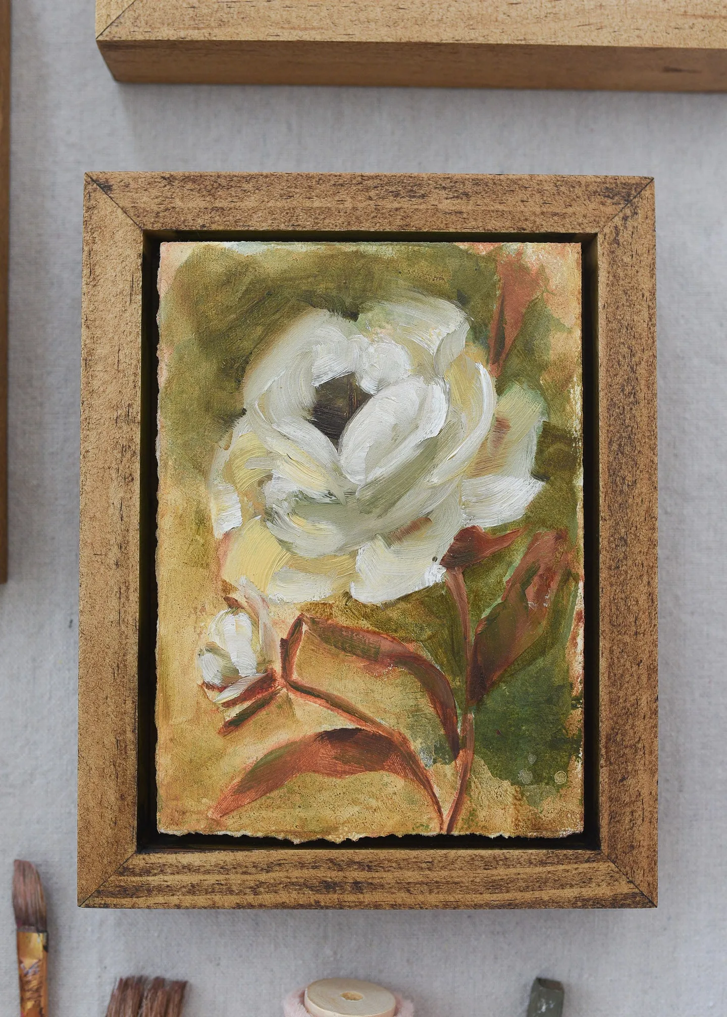 A creamy white rose against a warm green and soft yellow background, showcasing rich texture and depth through subtle color shifts.