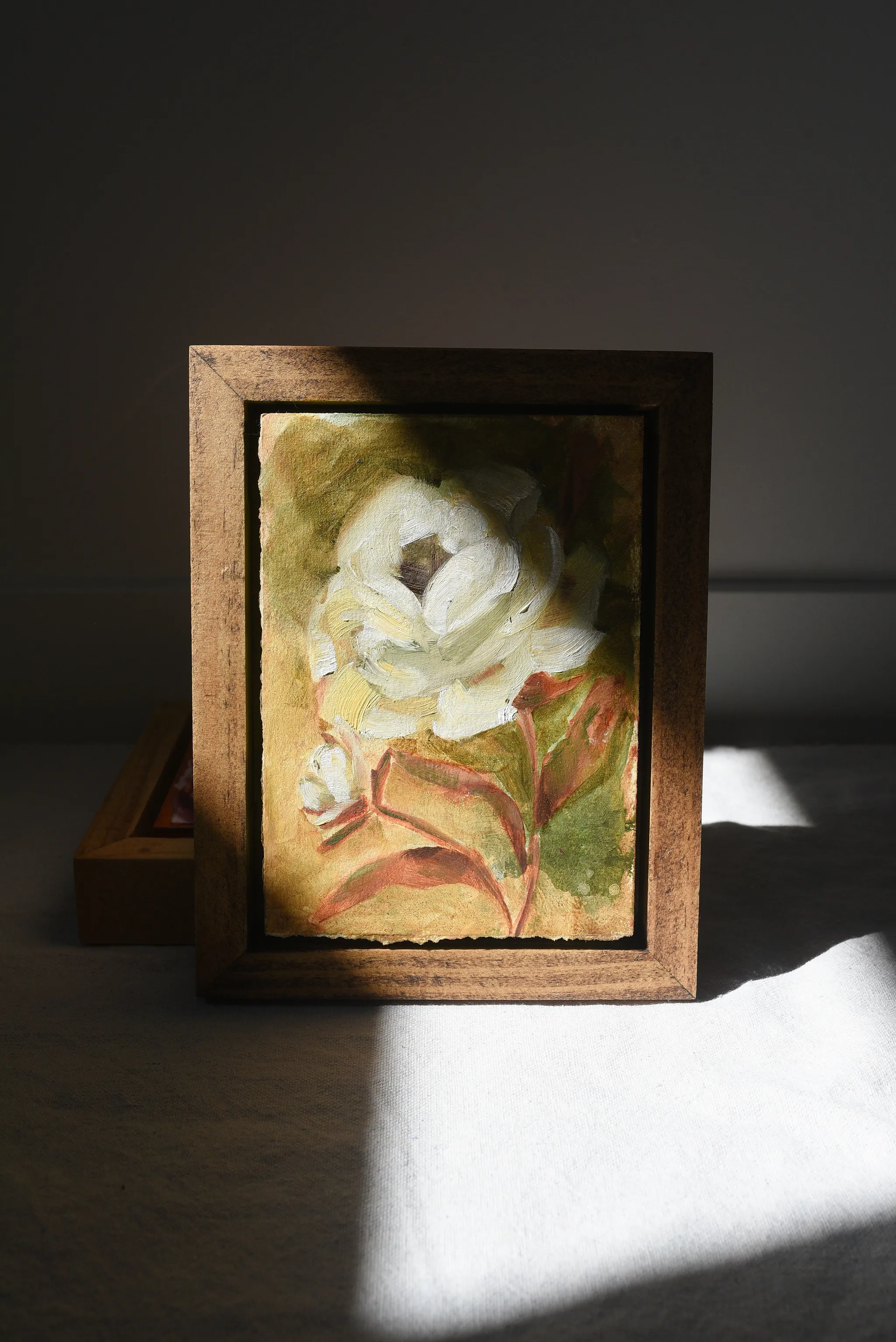 Enduring Bloom, view 3 of 9: A creamy white rose against a warm green and soft yellow background, showcasing rich texture and depth through subtle color shifts.