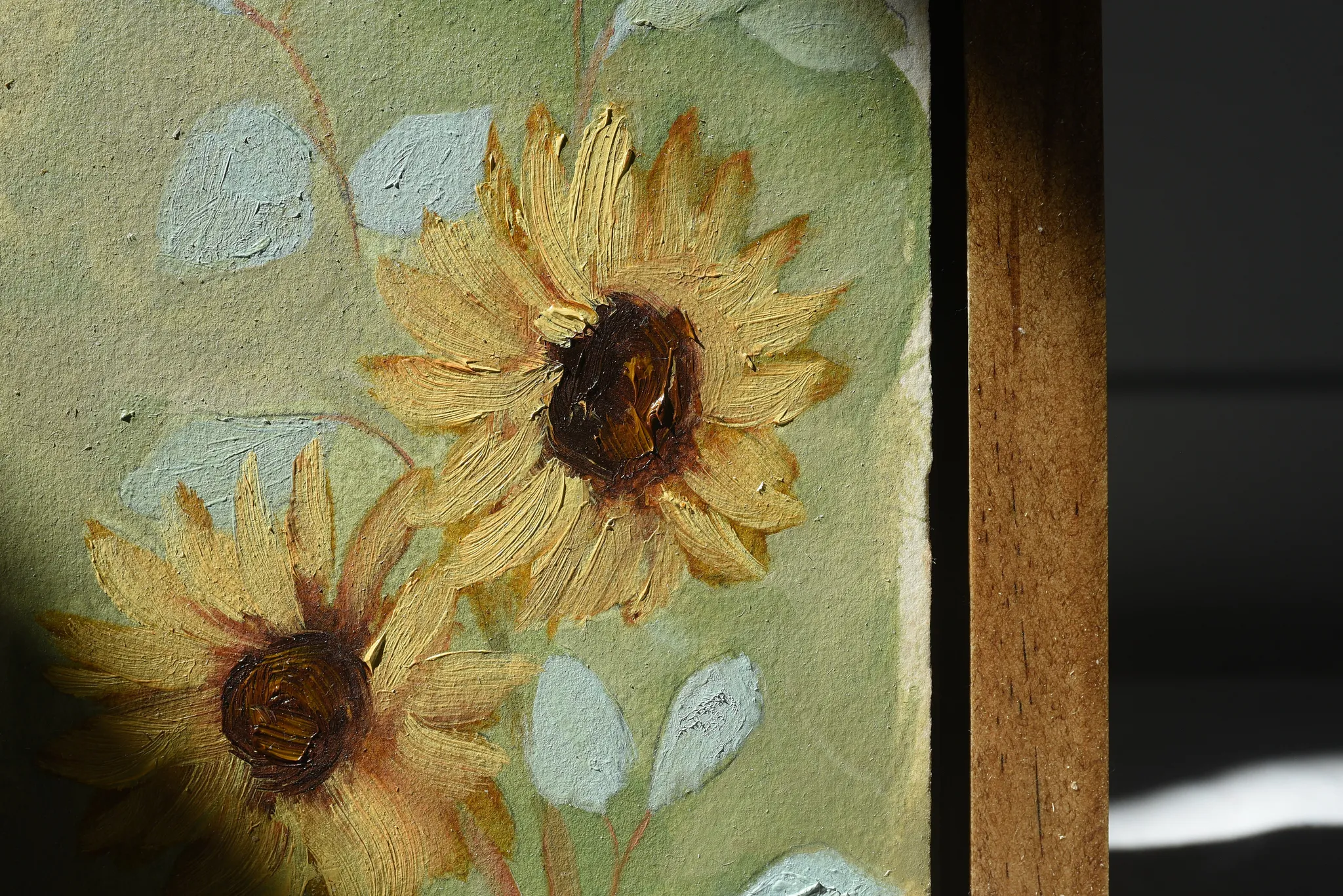 Harmony Bloom, view 2 of 12: three sunflowers radiating warmth against a light green backdrop, interwoven with delicate eucalyptus.