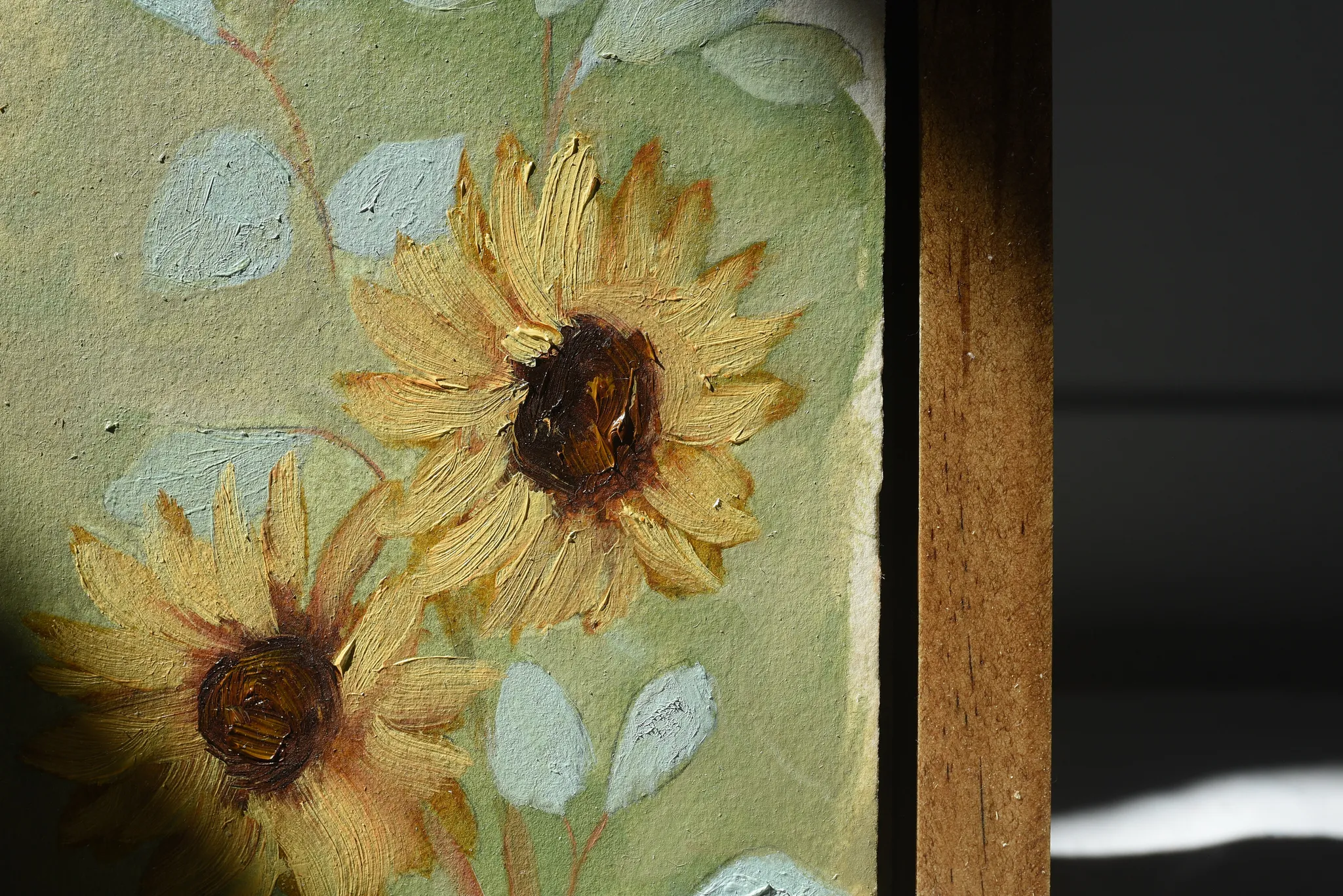 Harmony Bloom, view 4 of 12: three sunflowers radiating warmth against a light green backdrop, interwoven with delicate eucalyptus.