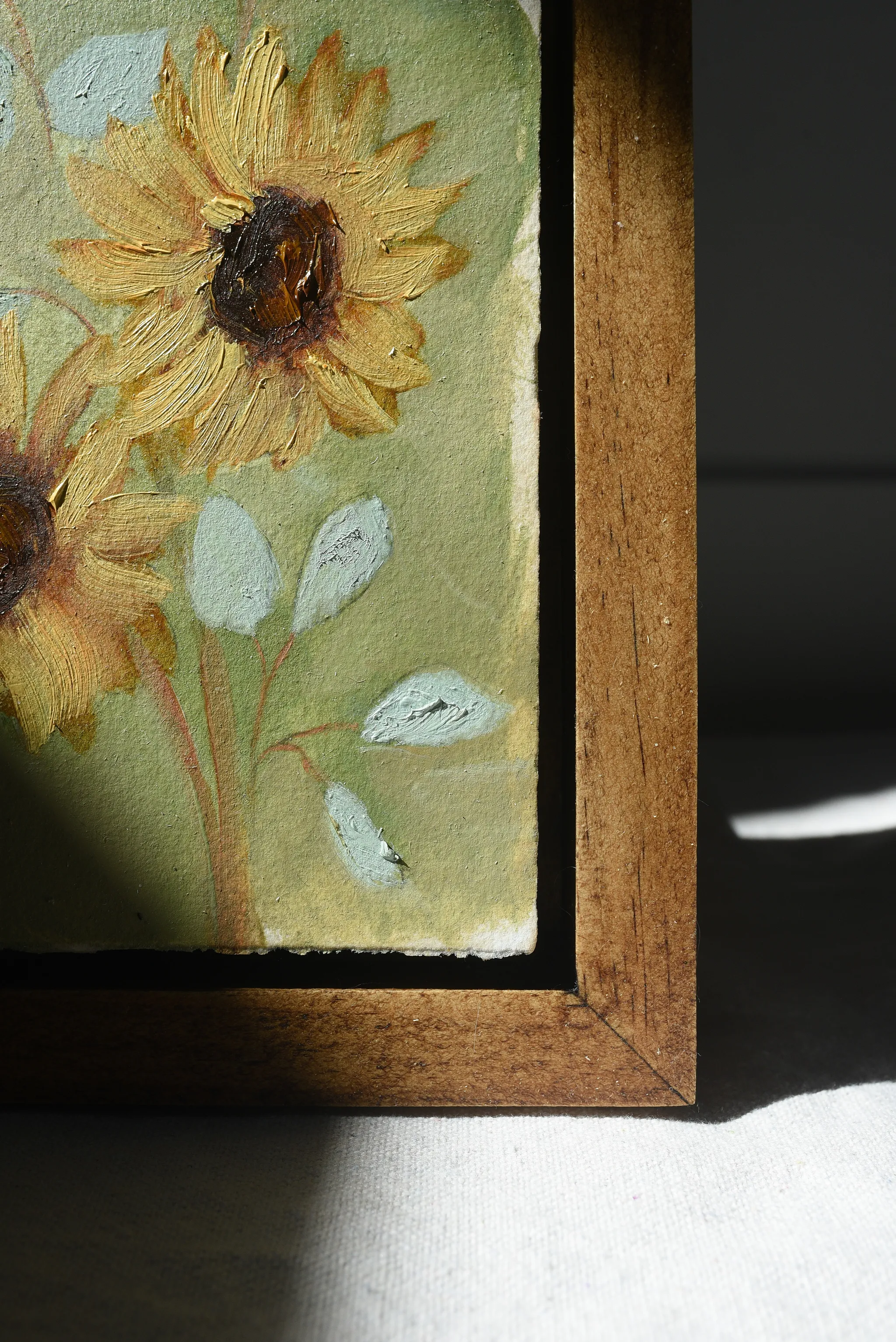 Harmony Bloom, view 7 of 12: three sunflowers radiating warmth against a light green backdrop, interwoven with delicate eucalyptus.