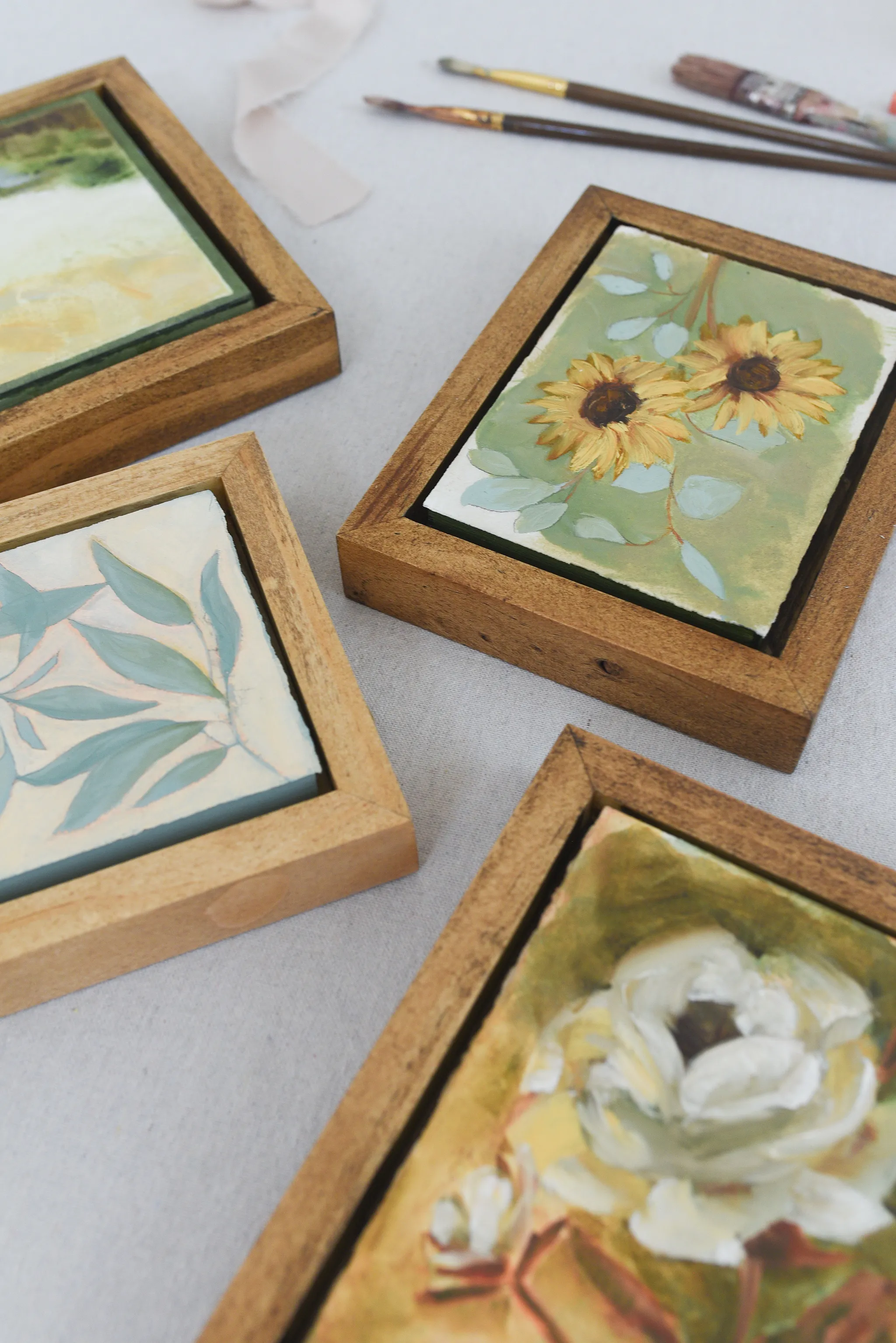 Harmony Bloom, view 8 of 12: three sunflowers radiating warmth against a light green backdrop, interwoven with delicate eucalyptus.