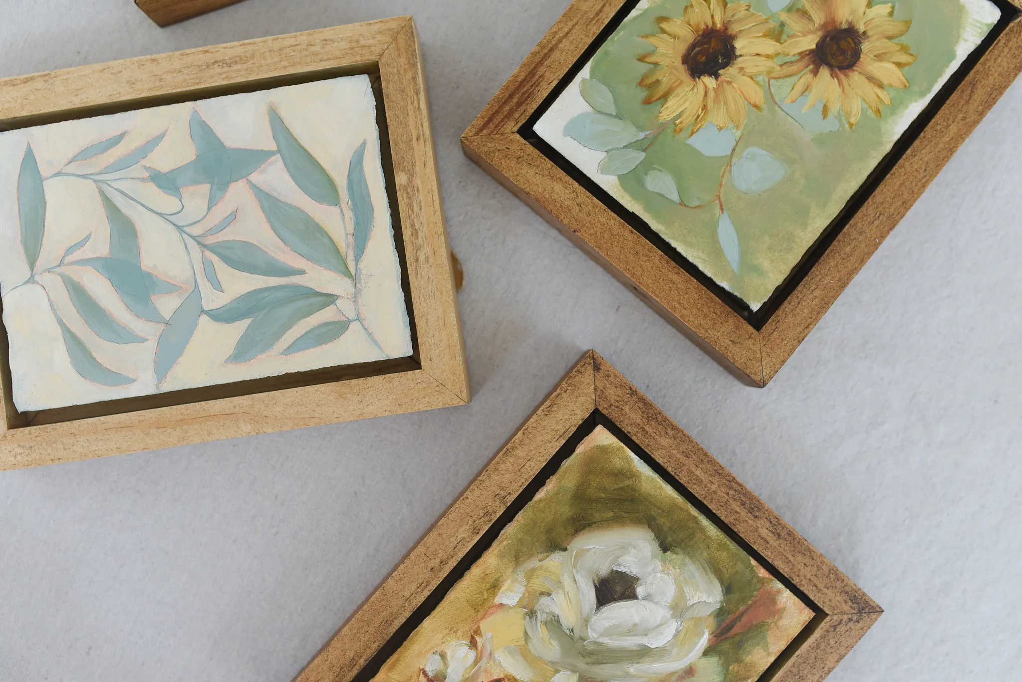 Harmony Bloom, view 9 of 12: three sunflowers radiating warmth against a light green backdrop, interwoven with delicate eucalyptus.