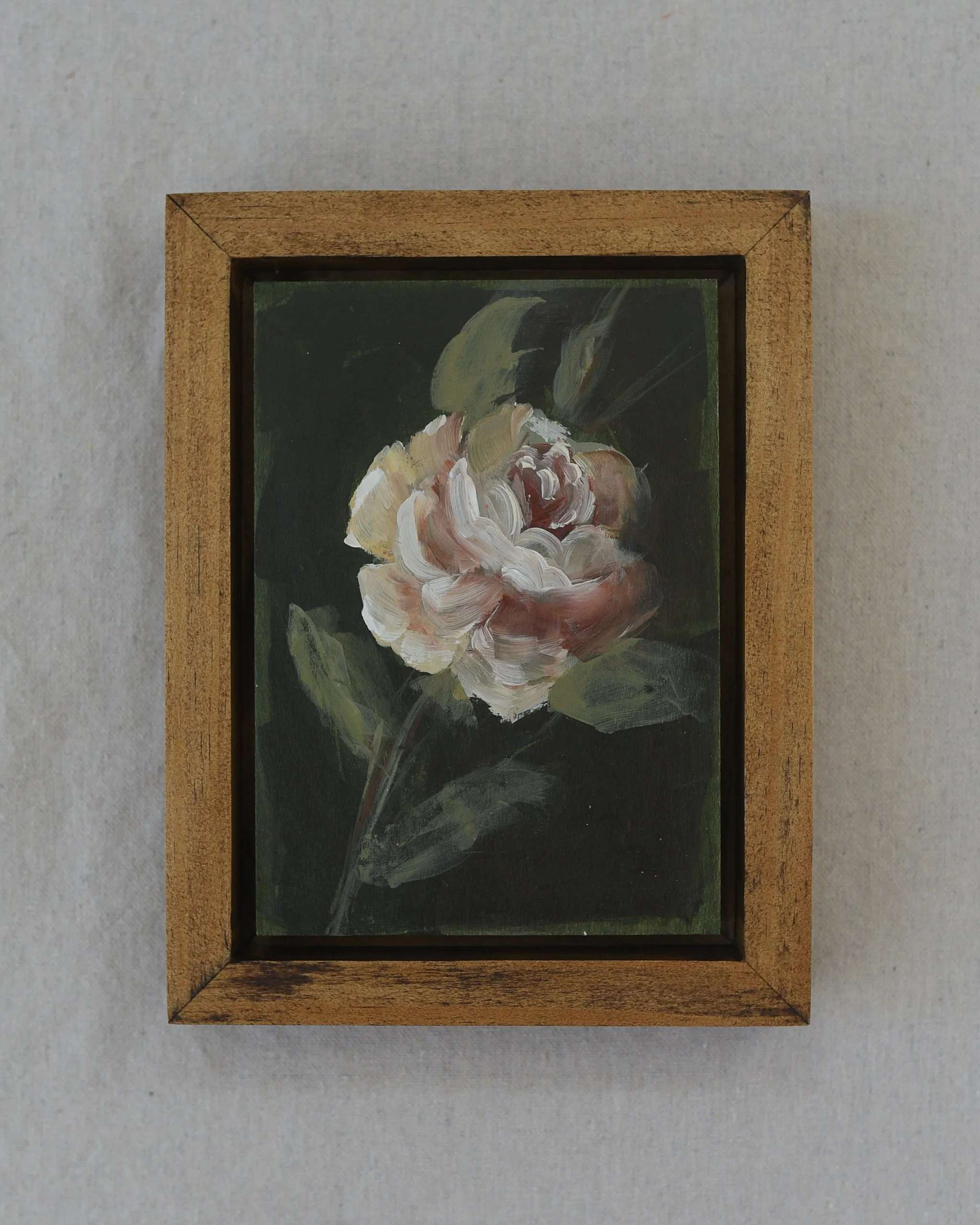 Olive Bloom, view 3 of 5: A delicate rose blooms against a dark olive green background, painted in acrylic on raw wood.