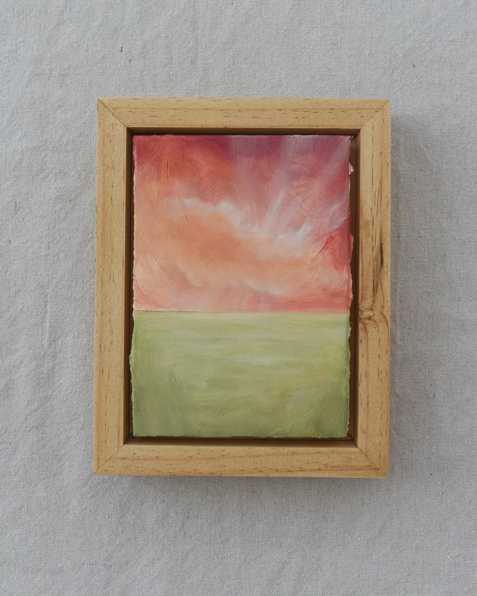 A serene sunrise peeking through soft clouds, with beams of light illuminating the scene.