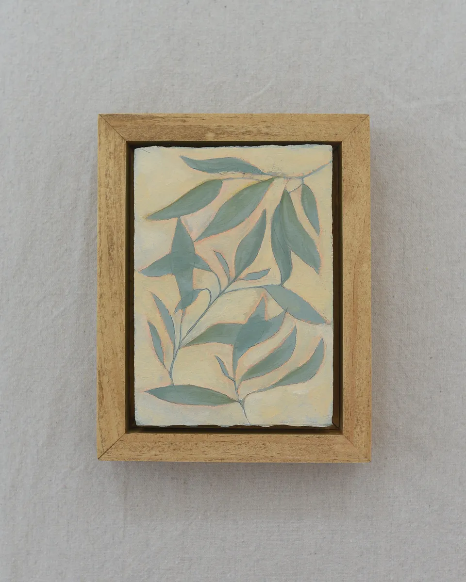 Mint-colored leaves gently resting on a creamy vanilla background, with subtle hints of peach.
