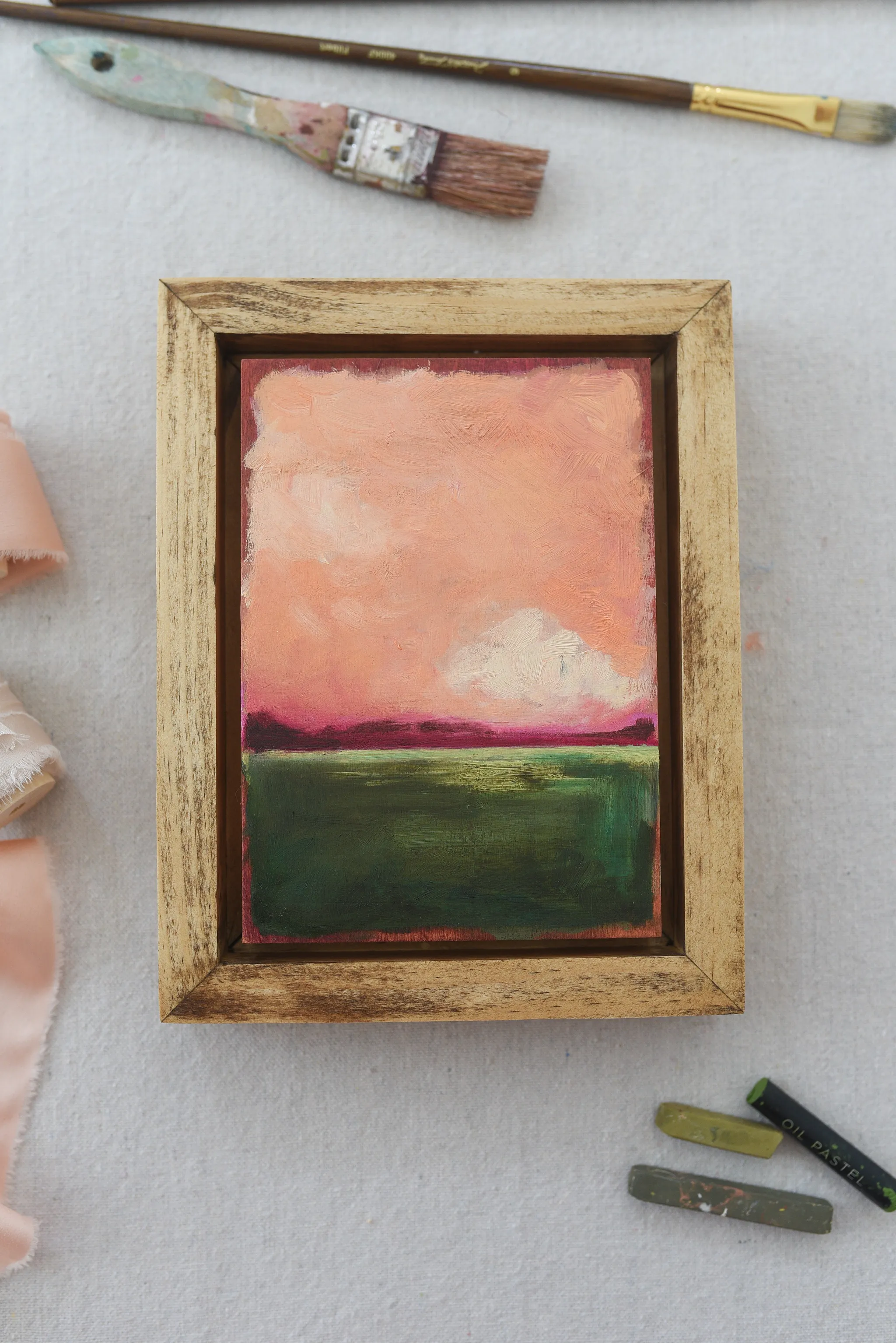 Reverie, view 3 of 12: A striking peach and deep magenta sky adorned with soft clouds, set against a backdrop of deep lush green.