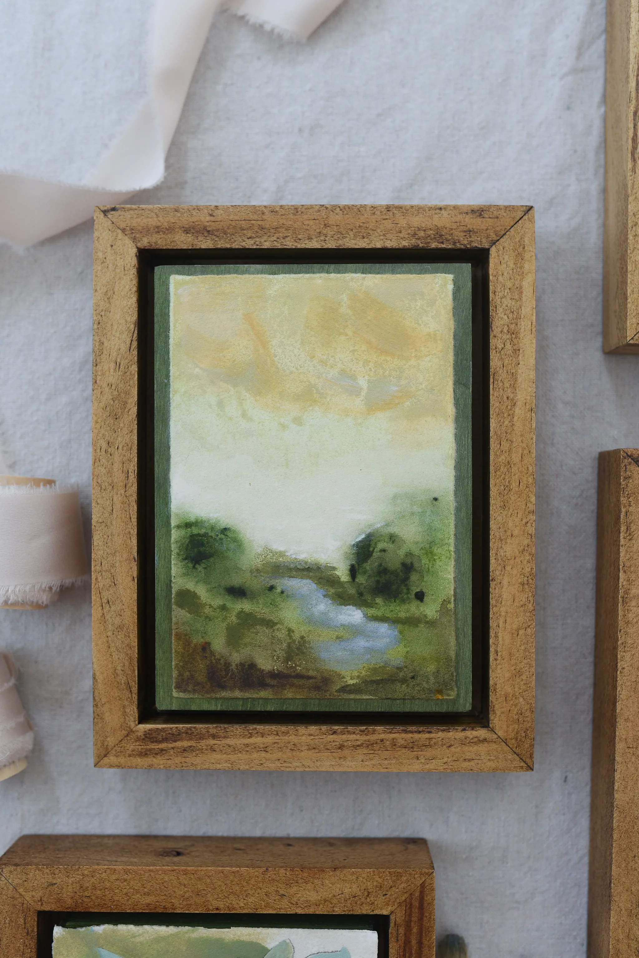 Whispering Stream, view 5 of 9: A moody scene of deep greens contrasted by a soft yellow sky, with a small stream gently wandering through the lush greenery.