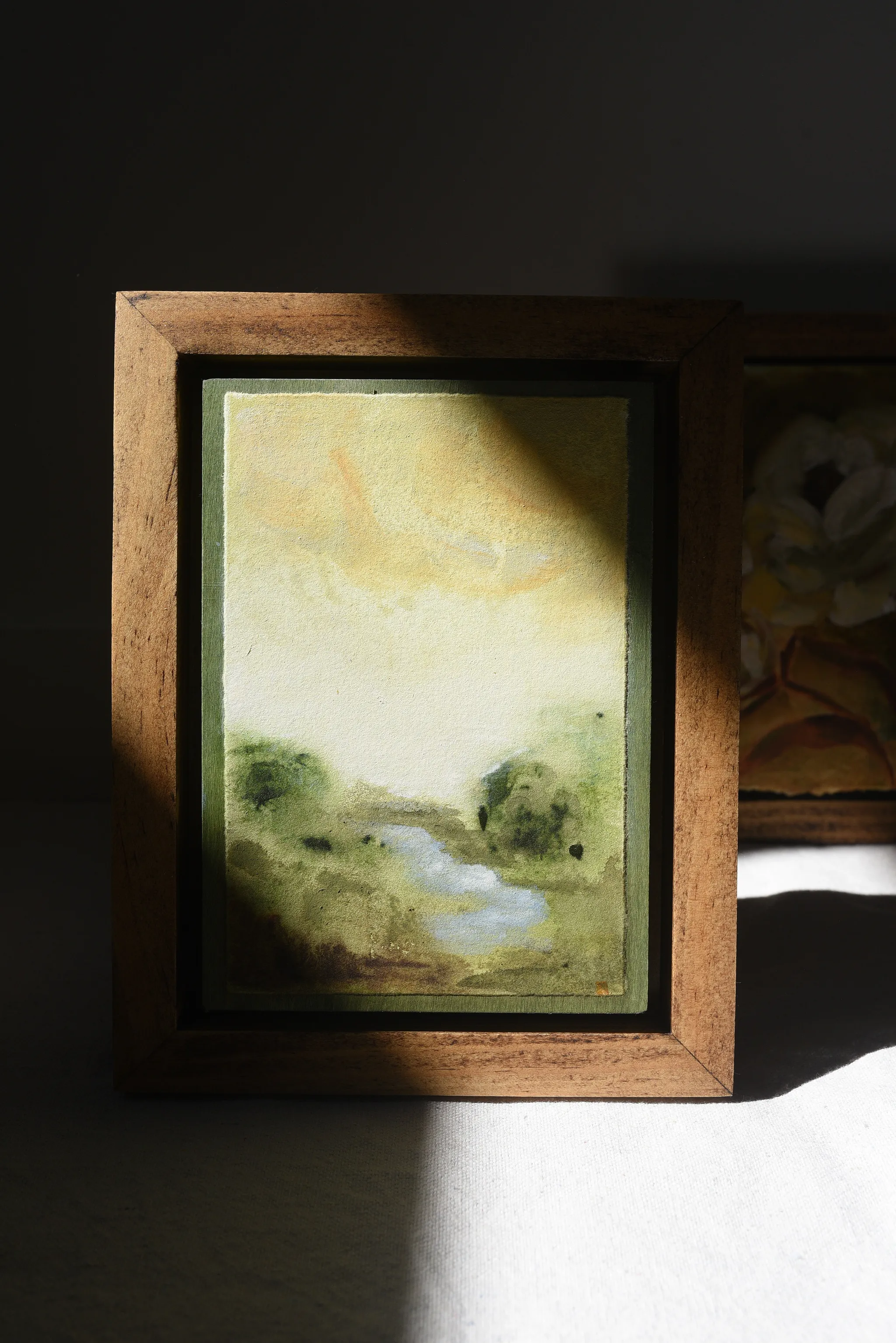 Whispering Stream, view 9 of 9: A moody scene of deep greens contrasted by a soft yellow sky, with a small stream gently wandering through the lush greenery.