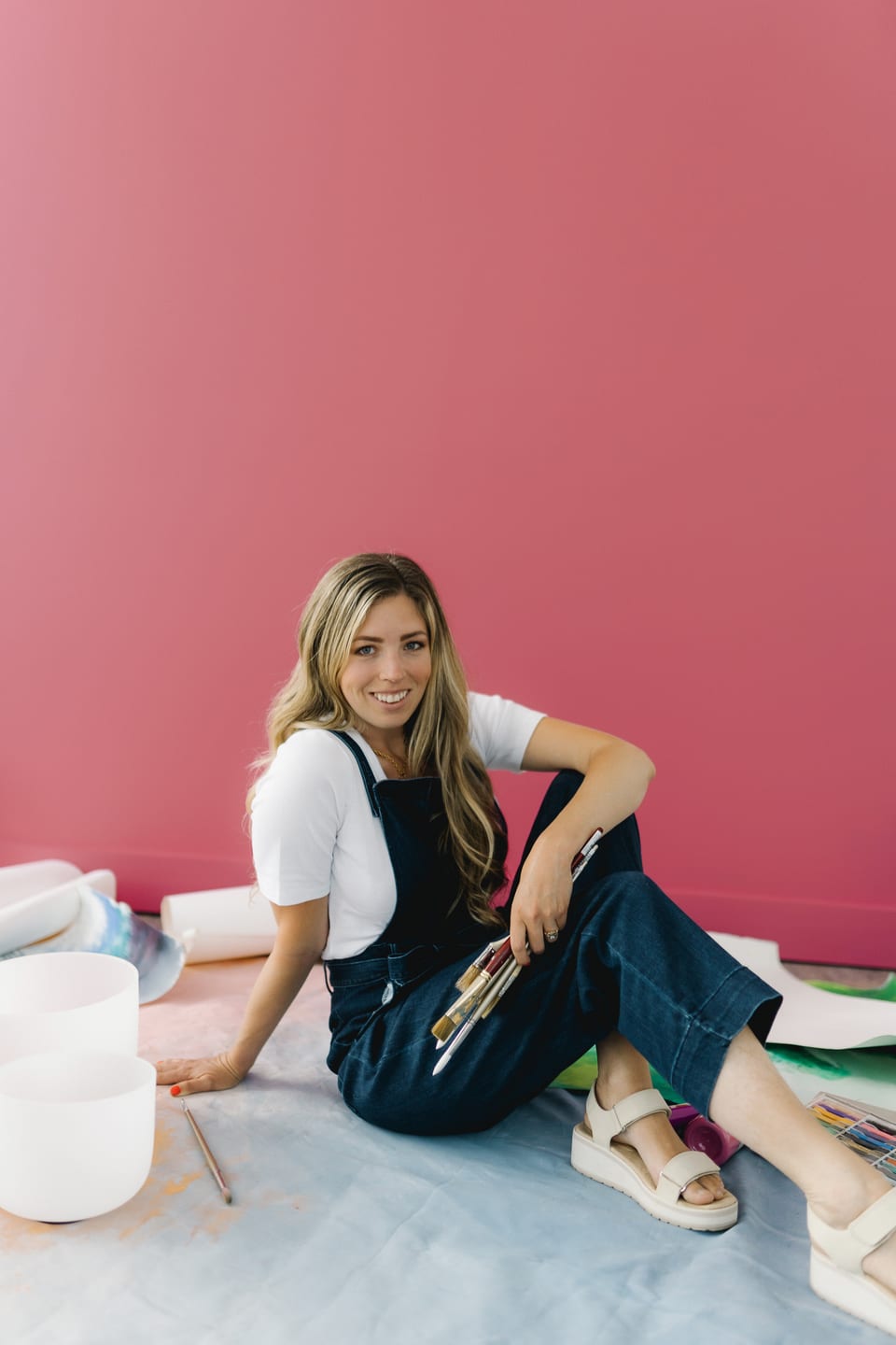 McKenna seated on the studio floor beside her singing bowls.